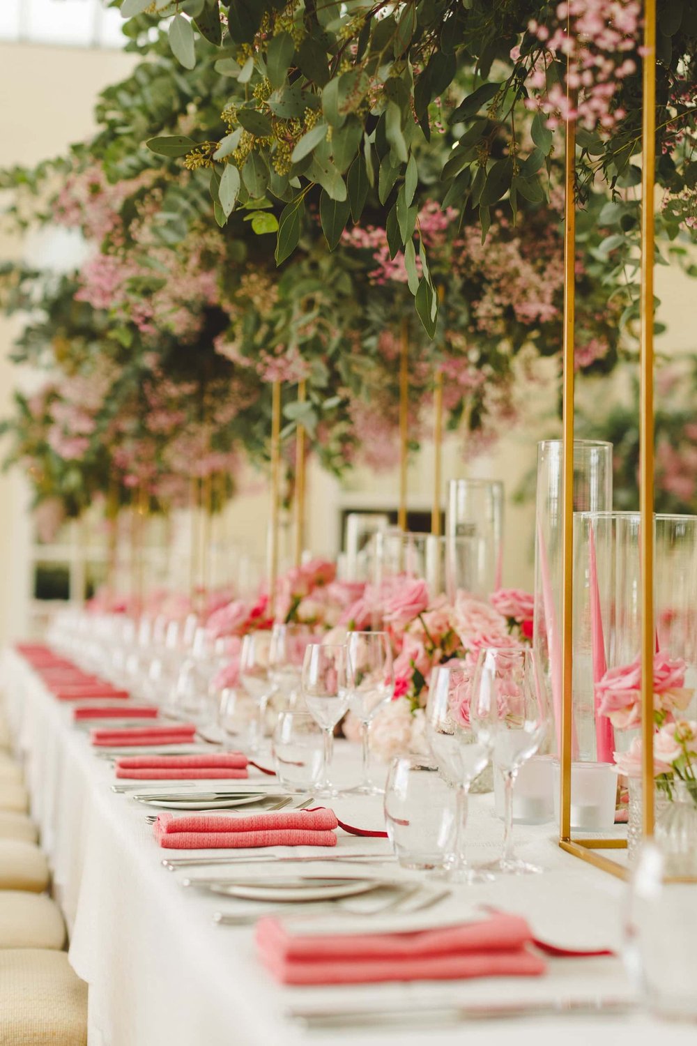 Wedding table adorned with pink roses and greenery, ideal for a romantic setting